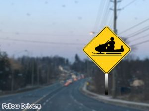 Snowmobiles crossing road sign